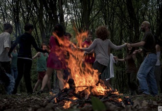 Dans în jurul focului în pădure